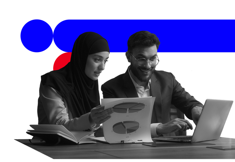 Two colleagues reviewing pie chart documents and a laptop in a black-and-white photo with blue and red graphic shapes.​​ 